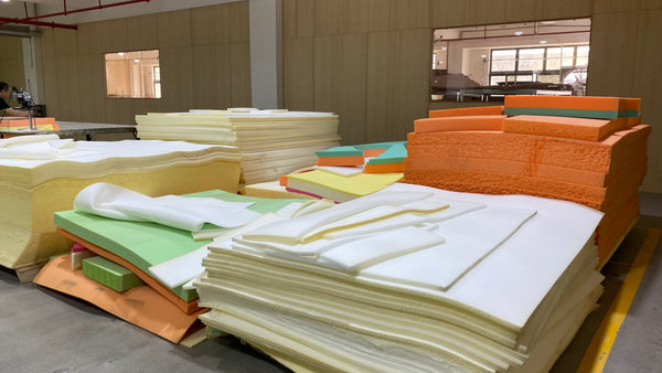 Stacks of colorful fabric sheets on a production line in a factory setting.