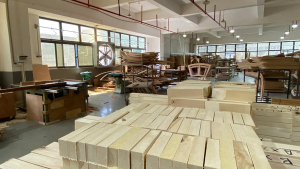 Wooden blocks stacked in a workshop with large windows and industrial elements.
