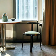 Puwabi X6226 continuous bentwood dining chair with a curved backrest and wooden legs, designed for contract dining spaces.
