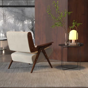 Modern chair with wooden armrests and white seat in a room with a side table and lamp.