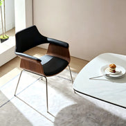 Puwabi X6119 sculptural bentwood contract dining armchair with curved wooden design and armrests, set against a neutral background.