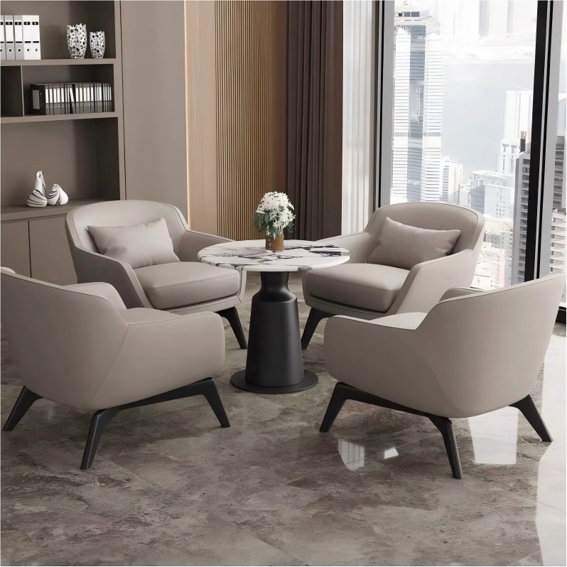 Modern living room with beige armchairs and a round table near large windows with city view.